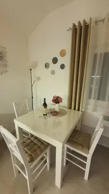a white dining room table with two chairs and a window at Smile 1 in Belgrade