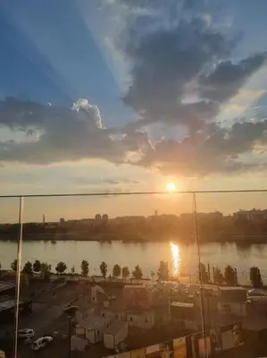 a view of a river with the sun in the sky at Exclusive apartman Belgrade Waterfront Terraces - Unique in Belgrade