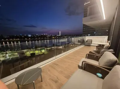 a room with a balcony with a view of a city at Exclusive apartman Belgrade Waterfront Terraces - Unique in Belgrade
