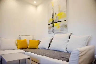 a white couch with yellow pillows in a room at Friendly Home ap Balkan-inn in Belgrade
