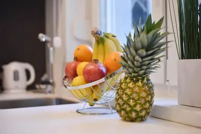 a bowl of fruit on a counter next to a pineapple at Friendly Home ap Balkan-inn in Belgrade