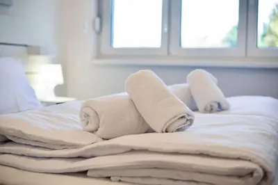 a stack of towels on top of a bed at Friendly Home ap Balkan-inn in Belgrade
