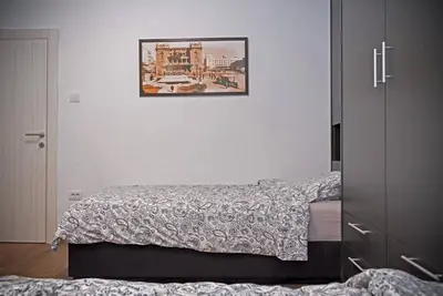 a bedroom with two beds and a picture on the wall at Anmador Stay in Belgrade