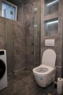 a bathroom with a toilet and a glass shower at Anmador Stay in Belgrade