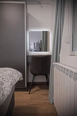 a bedroom with a bed and a chair and a window at Anmador Stay in Belgrade