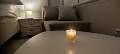 a candle sitting on a table in a bedroom at Maximus Apartments in Belgrade