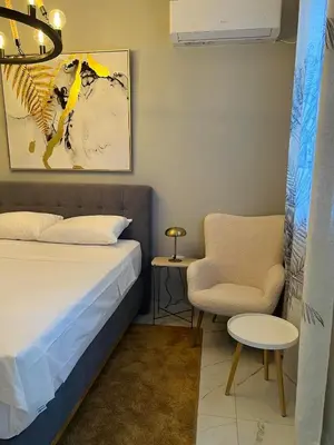 a bedroom with a bed and a chair at Maximus Apartments in Belgrade