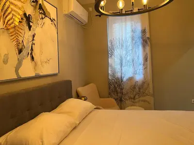 a bedroom with a bed and a window with a chandelier at Maximus Apartments in Belgrade