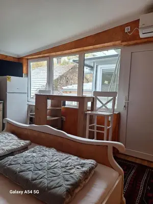 a bedroom with a bed and a kitchen with a table at Dream 6 in Belgrade