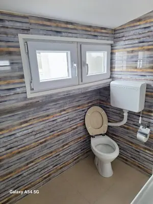 a bathroom with a toilet and two windows at Dream 6 in Belgrade