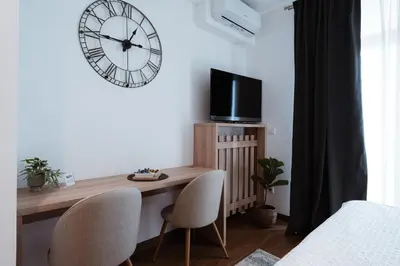 a room with a desk and a clock on the wall at inJoy in Belgrade