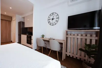 a bedroom with a desk and a clock on the wall at inJoy in Belgrade