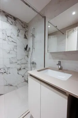 a white bathroom with a sink and a shower at inJoy in Belgrade
