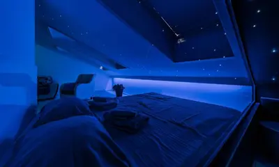 a bed in a room with blue lighting at Morning Wood - Skylight in Belgrade