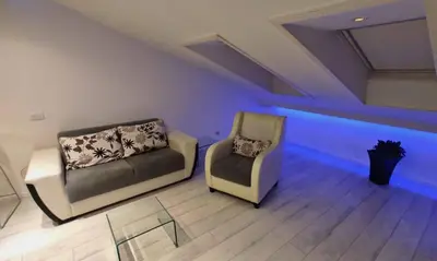 two chairs and a couch in a room with blue lights at Morning Wood - Skylight in Belgrade