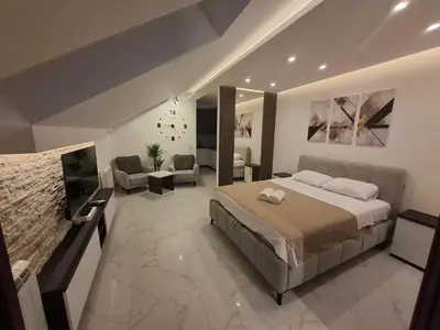 a bedroom with a large bed and a living room at Stef Lux Apartments in Belgrade