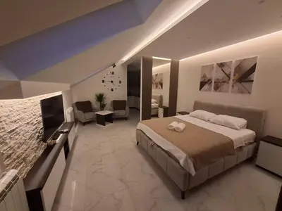 a bedroom with a large bed and a living room at Stef Lux Apartments in Belgrade