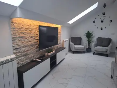 a living room with a television and two chairs at Stef Lux Apartments in Belgrade