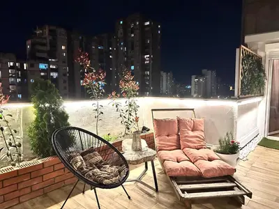a couch and chairs on a balcony at night at Golden Sunset Terrace Apartment Ana in Belgrade