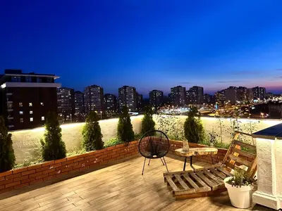 a balcony with a table and chairs and a view of a city at Golden Sunset Terrace Apartment Ana in Belgrade