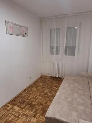 a white room with a bed and a window at Toni apartment in Belgrade