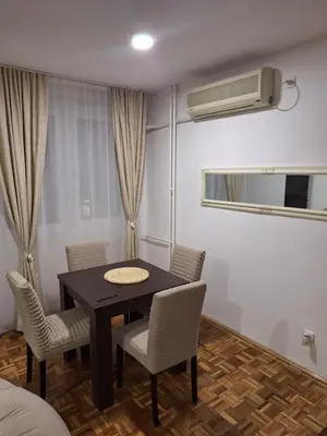 a dining room with a table and chairs and a air conditioner at Toni apartment in Belgrade