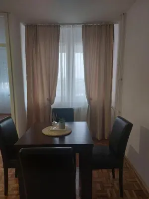 a dining room table with chairs and a window at Toni apartment in Belgrade