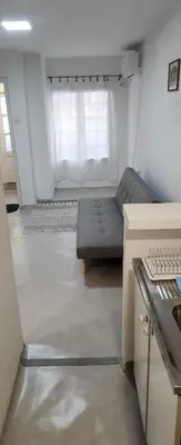 a living room with a couch in front of a window at Kristian 1 in Belgrade