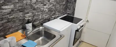 a kitchen with a sink and a brick wall at Kristian 1 in Belgrade