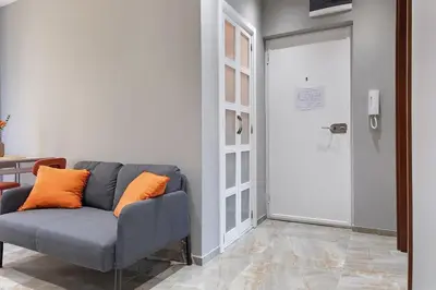 a living room with a couch with orange pillows on it at Apartment Paradise Slavija Tres in Belgrade