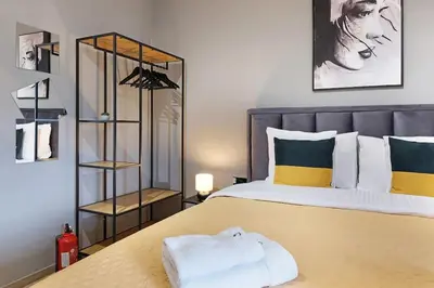 a bedroom with a large bed with yellow and green pillows at Apartment Paradise Slavija Tres in Belgrade