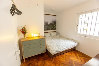 a bedroom with a bed and a dresser and a window at Lule garden apartment in Belgrade