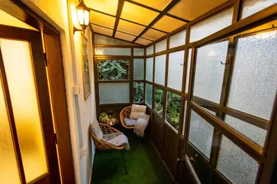 a small balcony with two chairs and a table at Lule garden apartment in Belgrade