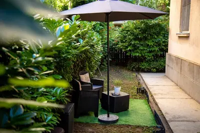 a patio with a table and an umbrella and chairs at Lule garden apartment in Belgrade
