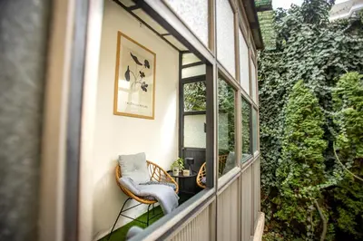 a balcony with a chair and a table and a window at Lule garden apartment in Belgrade