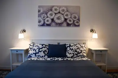 a bedroom with a blue bed with two night stands at Present Perfect Stay in Belgrade
