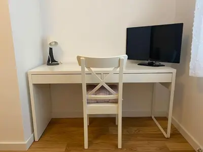a white desk with a computer monitor and a chair at Present Perfect Stay in Belgrade
