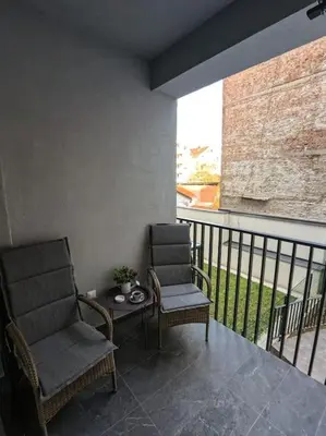 two chairs and a table on a balcony at Present Perfect Stay in Belgrade