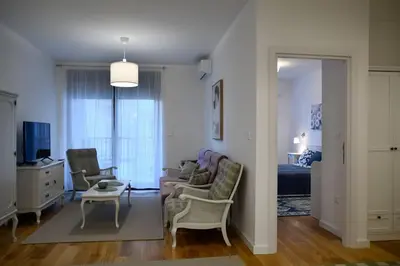 a living room with chairs and a couch and a table at Present Perfect Stay in Belgrade