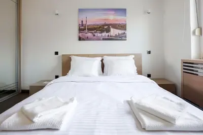 a large white bed with two white towels on it at Emma in Belgrade