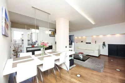 a living room with a table and white chairs at Emma in Belgrade