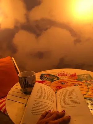 a table with a book and a cup on it at Oblak in Belgrade