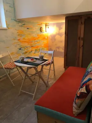 a room with a table and chairs and a painting at Oblak in Belgrade