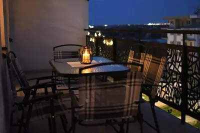 a table and chairs on a balcony with a candle at Loft 43 in Stara Pazova