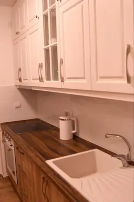 a kitchen with white cabinets and a sink at Loft 43 in Stara Pazova
