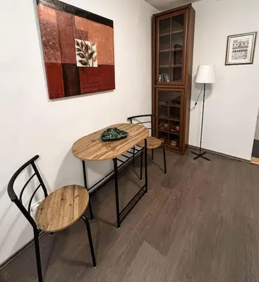 a room with a table and two chairs and a lamp at Lilly's Apartment in Belgrade