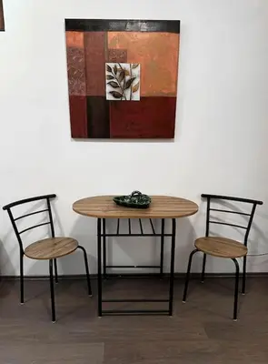 a table and two chairs in front of a painting at Lilly's Apartment in Belgrade