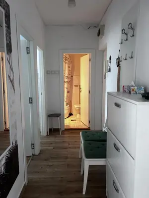 a living room with a green ottoman and a hallway at Surya in Belgrade