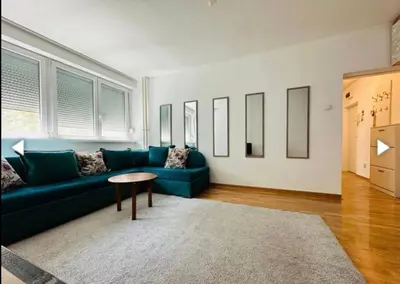 a living room with a blue couch and a table at Surya in Belgrade