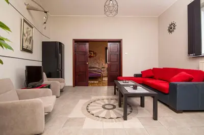 a living room with a red couch and a table at Njegoševa Presidential Suite Vračar in Belgrade